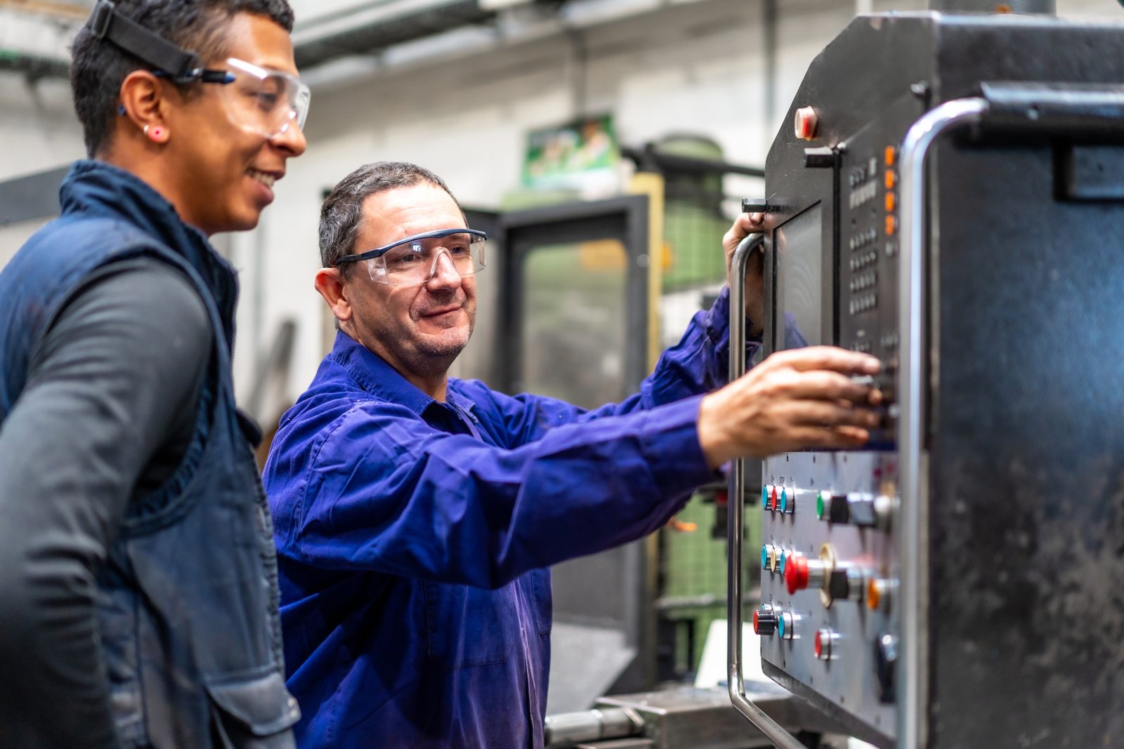 Senior technician coaching a new hire on equipment